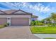 Home exterior with a double garage, manicured lawn, and elegant stone pathway in a welcoming neighborhood at 3105 Formia Ct, Bradenton, FL 34211