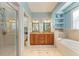 A modern bathroom with a glass-enclosed shower, double vanity, and soaking tub at 312 61St St # A, Holmes Beach, FL 34217