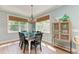 Light-filled dining room features a chandelier, wood floors, and large windows overlooking the backyard at 312 61St St # A, Holmes Beach, FL 34217