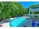 A backyard pool with lounge chairs and lush tropical landscaping at 312 61St St # A, Holmes Beach, FL 34217