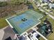 Aerial view of community tennis and basketball courts with adjacent playground for outdoor fun at 5718 Broad River Run, Ellenton, FL 34222