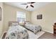 Bright bedroom with two twin beds, ceiling fan, and natural light at 5718 Broad River Run, Ellenton, FL 34222