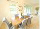 Bright dining area features a modern light fixture and opens up to sliding glass doors to the lanai at 5718 Broad River Run, Ellenton, FL 34222