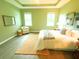 Serene main bedroom showcases tray ceilings, natural light, and a cozy sitting area at 5718 Broad River Run, Ellenton, FL 34222