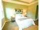 Bright main bedroom with tray ceiling, two windows, and neutral-toned walls at 5718 Broad River Run, Ellenton, FL 34222