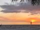Serene beach view featuring a stunning sunset and a lone fisherman enjoying the tranquil evening at 6796 Gasparilla Pines Blvd # 45, Englewood, FL 34224
