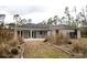 An open back patio with white french doors leading indoors and a well manicured backyard with a garden at 8570 Tropicaire Blvd, North Port, FL 34291