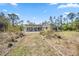 Expansive backyard featuring a covered patio, lawn, and natural landscaping at 8570 Tropicaire Blvd, North Port, FL 34291