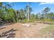 Large wooded lot with an area cleared for entertaining around a fire pit at 8570 Tropicaire Blvd, North Port, FL 34291