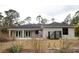 Back of a single-story home showing a covered patio and privacy fence and natural surroundings at 8570 Tropicaire Blvd, North Port, FL 34291