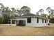 Wide angle shot of the back of a house with a fenced-in area and lush trees in the background at 8570 Tropicaire Blvd, North Port, FL 34291