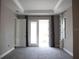Spacious bedroom featuring tray ceilings, neutral walls, plush carpeting, and access to the outdoors through glass doors at 8570 Tropicaire Blvd, North Port, FL 34291