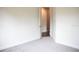Neutral bedroom with carpet flooring leading to a hallway, white walls, and ample space at 8570 Tropicaire Blvd, North Port, FL 34291