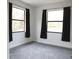 Minimalist bedroom with plush gray carpeting and natural light from the two large windows at 8570 Tropicaire Blvd, North Port, FL 34291
