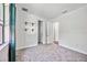 Bright bedroom features neutral carpet, white walls, and convenient shelving at 8570 Tropicaire Blvd, North Port, FL 34291