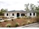 Home exterior featuring arched windows, covered front porch, and professional landscaping at 8570 Tropicaire Blvd, North Port, FL 34291
