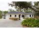 Charming home exterior with arched windows, covered front porch, and a gravel driveway at 8570 Tropicaire Blvd, North Port, FL 34291