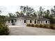 Charming home exterior with arched windows, porte-cochere, gray paint and gravel driveway at 8570 Tropicaire Blvd, North Port, FL 34291