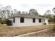 Backyard exterior of home featuring a dark roof and well-maintained landscaping at 8570 Tropicaire Blvd, North Port, FL 34291