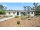 Charming single-story home featuring a blue door, neutral paint, and natural landscaping at 8570 Tropicaire Blvd, North Port, FL 34291