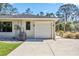 Attached garage with a white door, next to the yard at 8570 Tropicaire Blvd, North Port, FL 34291