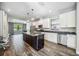 Modern kitchen featuring white cabinets, stainless steel appliances, and a center island at 8570 Tropicaire Blvd, North Port, FL 34291