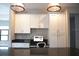 Kitchen with built-in desk area, white cabinets, granite countertops, and stylish pendant lighting at 8570 Tropicaire Blvd, North Port, FL 34291