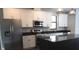 Modern kitchen features stainless steel appliances, granite countertops, white cabinets, and a kitchen island at 8570 Tropicaire Blvd, North Port, FL 34291