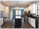 Bright kitchen features white cabinets, stainless steel appliances, black granite counters, island, and built-in desk at 8570 Tropicaire Blvd, North Port, FL 34291