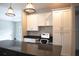 Kitchen features a built-in desk area, white cabinets, granite countertops, and modern pendant lighting at 8570 Tropicaire Blvd, North Port, FL 34291