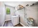 This laundry room has wood floors, a window, a washer, and wire rack shelving at 8570 Tropicaire Blvd, North Port, FL 34291