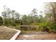 Scenic pond surrounded by lush trees, creating a serene and private natural setting at 8570 Tropicaire Blvd, North Port, FL 34291