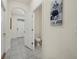 Hallway leading to a half bath, featuring tile floors and stylish decor at 8995 Milestone Dr, Sarasota, FL 34238