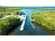 Aerial view shows the community boat lock and waterways surrounded by lush greenery on a bright, sunny day at 9464 St Marys Ct, Port Charlotte, FL 33981