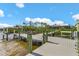 Exterior view of a private dock with a boat lift and fish cleaning station, adjacent to a home under a cloudy blue sky at 9464 St Marys Ct, Port Charlotte, FL 33981