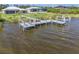 Waterfront views from the private dock on Interceptor Lagoon, featuring a boat lift and deck chairs at 9464 St Marys Ct, Port Charlotte, FL 33981