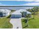 An aerial view shows a contemporary home with a three-car garage, manicured lawn, and a waterfront view at 9464 St Marys Ct, Port Charlotte, FL 33981