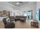Open-concept living room with tile floors, tray ceilings, and sliding glass doors leading to the backyard at 9464 St Marys Ct, Port Charlotte, FL 33981