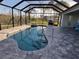 A paved deck surrounds the screened-in pool and built-in spa at 9464 St Marys Ct, Port Charlotte, FL 33981