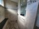 Walk-in shower features decorative tile accents, a built-in bench, and a rainfall shower head at 9464 St Marys Ct, Port Charlotte, FL 33981