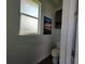 Toilet room with a frosted window and a cabinet for storage at 9464 St Marys Ct, Port Charlotte, FL 33981