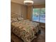Bright bedroom with a sea-themed bedspread, window with a backyard view, and modern lighting at 4553 Linwood St, Sarasota, FL 34232