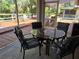 Enclosed patio with cushioned chairs around glass table, perfect for relaxation at 4553 Linwood St, Sarasota, FL 34232