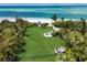 Expansive backyard with manicured lawn, beachfront access, fire pit and seating at 1067 Westway Dr, Sarasota, FL 34236