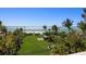 Expansive backyard with lush lawn, mature trees, and stunning beachfront access at 1067 Westway Dr, Sarasota, FL 34236