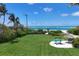 Lush backyard overlooking a beautiful white sand beach and sparkling turquoise water at 1067 Westway Dr, Sarasota, FL 34236