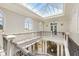 A grand foyer with skylights, wrought iron railings, and arched windows showcases the home's architectural details at 1067 Westway Dr, Sarasota, FL 34236