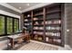 Cozy office space with a large bookshelf, work desk, and a leafy outdoor view at 1067 Westway Dr, Sarasota, FL 34236