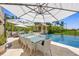 Outdoor dining area with seating for twelve, overlooking the pool and lush greenery at 1067 Westway Dr, Sarasota, FL 34236