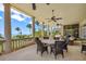 Elegant covered patio with outdoor dining, ceiling fans, and beautiful ocean views at 1067 Westway Dr, Sarasota, FL 34236